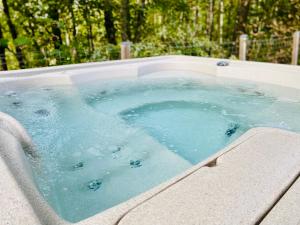 a jacuzzi tub with blue water in it at Le Hygge Chalet Gérardmer-Spa in Anould +57 photos