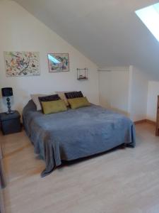 a bedroom with a large bed in a attic at La longère in Épineu-le-Chevreuil