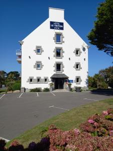 een groot wit gebouw met een bord erop bij The Originals City, Hôtel Armen Le Triton, Roscoff in Roscoff