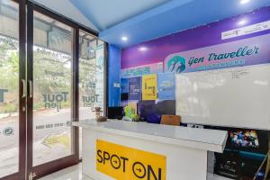 a reception desk in a showroom with posters on the wall at Ijen Traveller & Homestay in Banyuwangi