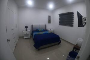 a bedroom with a bed and a flat screen tv at Paraíso en Rosarito a pie de la playa in Rosarito +28 photos