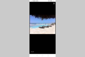 an iphone screen showing a picture of a beach at Paraíso en Rosarito a pie de la playa in Rosarito