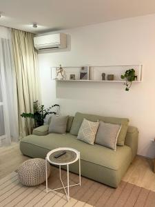 White Goose في ايفانو - فرانكيفسك: غرفة معيشة مع أريكة خضراء وطاولة