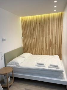 a bed with a wooden headboard in a room at White Goose in Ivano-Frankivsʼk