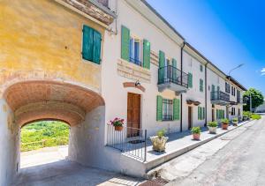una fila de edificios con puertas y ventanas verdes y amarillas en Casa di nonna Ines 2 - Hideaway in Monferrato con Vista sulle Colline e Piscina en Gabiano