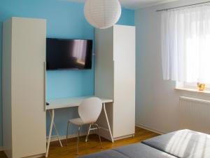 1 dormitorio con escritorio y TV en la pared en geräumige Ferienwohnung in Kindelbrück für bis zu 4 Personen - barriefrei, en Kindelbrück
