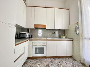 cocina con armarios blancos y fogones en CIT MA BEL, en Cuneo