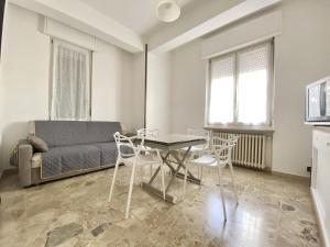 a living room with a table and chairs and a bed at CIT MA BEL in Cuneo