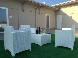 un gruppo di sedie e un tavolo con bottiglie di vino di TERRAZZA Rooms a Castrezatto