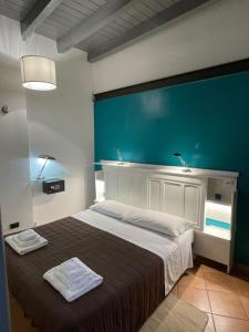 ein Schlafzimmer mit einem großen Bett mit blauer Wand in der Unterkunft RUBRA Apartments in Parma