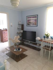 un soggiorno con TV a schermo piatto e tavolo di Nikoleta Apartment a Chania