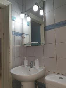 W łazience znajduje się umywalka, toaleta i lustro. w obiekcie Nikoleta Apartment w Chanii