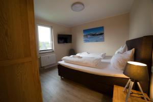 een slaapkamer met een bed met witte kussens en een raam bij Ferienwohnung Manito im Haus Jade in Winterberg
