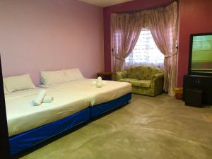 um quarto com uma cama, um sofá e uma televisão em BUKIT INDAH HOMESTAY em Bentong