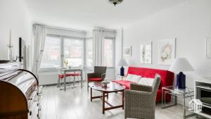 sala de estar con sofá rojo y mesa en Hamburg Niendorf-Suite, en Hamburgo