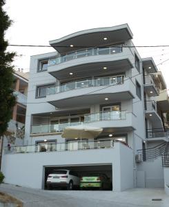 an apartment building with two cars parked in front of it at Blue4Aqua Apartments in Kavala
