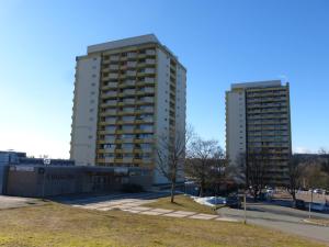 two tall buildings in a parking lot next to a building at App 342 gemütlich und mit Weitblick in Braunlage