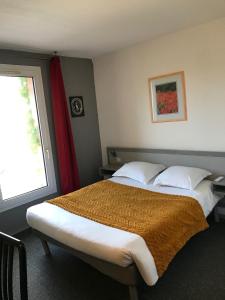 a bedroom with a large bed and a window at Hôtel Amaya in Ambarès-et-Lagrave