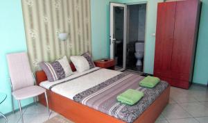 sypialnia z łóżkiem z dwoma zielonymi ręcznikami w obiekcie Стаи за нощувки "Азалия" 