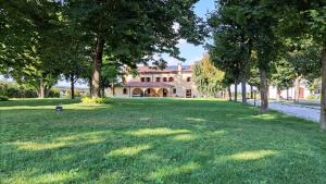 a large yard with trees in front of a house at Agriturismo La Foscarina in Vescovana
