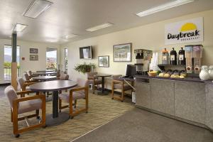 a restaurant with tables and chairs and a bar at Days Inn by Wyndham Missoula Airport in Wye