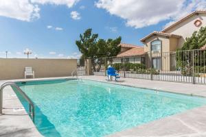 uma piscina com uma cadeira azul em frente a uma casa em Days Inn by Wyndham Willcox em Willcox