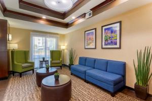 a living room with a blue couch and two green chairs at Comfort Suites Little Rock in Little Rock