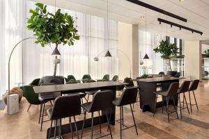 une salle à manger avec des tables noires et des chaises vertes dans l'établissement Comwell Copenhagen Portside Dolce by Wyndham, à Copenhague