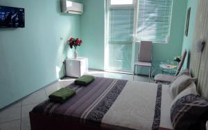 sypialnia z łóżkiem z zielonymi poduszkami w obiekcie Стаи за нощувки "Азалия" 
