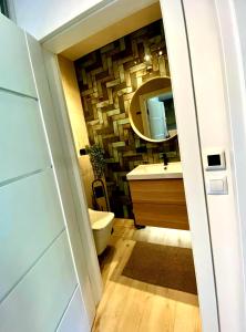 a bathroom with a toilet and a mirror at Apartament Jurata Deluxe in Jurata