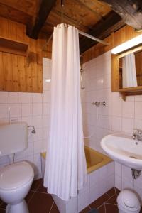 ein Badezimmer mit einem weißen Duschvorhang und einem Waschbecken in der Unterkunft Hofraithe Park in Rosenthal