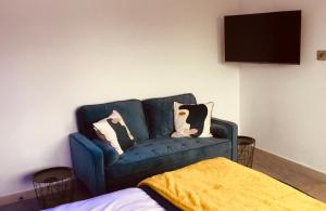 un sofá azul con almohadas en una habitación en Bed@BroadOak en Sturminster Newton