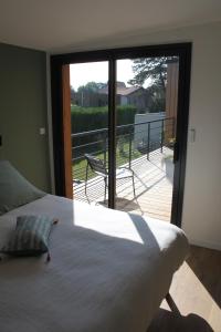 - une chambre avec un lit et un balcon avec une porte coulissante en verre dans l'établissement Bread et Couette, à Lyon