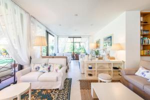 una sala de estar con muebles y ventanas blancos. en Hotel Andreaneri, en Marina di Pietrasanta