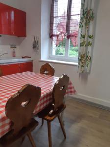 a kitchen with a table with a red and white checkered table cloth at Gîte La Fabrique , spa , bain nordique in Les Fontenelles
