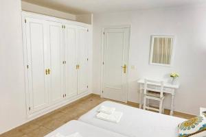 a white room with a bed and a desk at PUERTAS AL MAR in Cala en Blanes