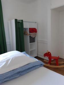 Schlafzimmer mit einem weißen Bett und einem Kühlschrank in der Unterkunft Gîte La Fabrique , spa , bain nordique in Les Fontenelles