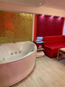ラメンスコエにあるWesendorf Hotel in Ramenskoyeの広いバスルーム(バスタブ、赤いソファ付)
