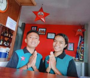 a man and a woman sitting at a table in a bar at Bintang by Tobias Lodge Cafe & Restaurant in Kelimutu