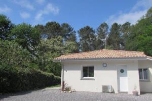 a small white house with trees in the background at Maison Solyselva Piscine- Proche océan- Climatisée in Saubion