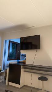 ein Wohnzimmer mit einem an der Wand hängenden TV in der Unterkunft Cosy studio near by AirPort, 2min from train! in Vantaa
