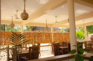 a patio with tables and chairs and a fence at Sunbrella Boutique Hotel in Michamvi