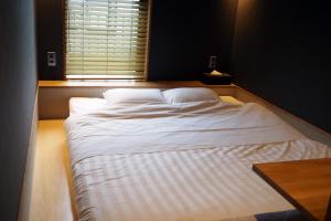 Postel nebo postele na pokoji v ubytování Yumoto Station Hotel MIRAHAKONE
