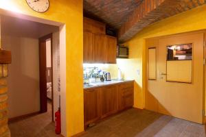 uma cozinha com paredes amarelas e um relógio na parede em Apartma Zgodba em Cerklje na Gorenjskem