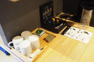 a table with white cups on top of it at Yumoto Station Hotel MIRAHAKONE in Hakone