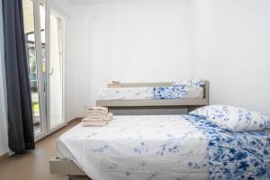 sypialnia z łóżkiem z niebiesko-białymi prześcieradłami w obiekcie Villa Orietta w mieście Fontane Bianche