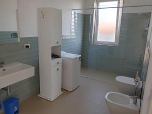 baño con lavabo y aseo y ventana en Villa Orietta, en Fontane Bianche
