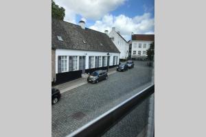 een uitzicht vanuit een raam van een straat met geparkeerde auto's bij Duplex Appartement Nokeredorp - Vlaamse Ardennen in Kruisem