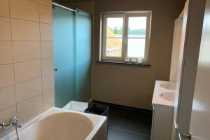 a bathroom with a sink and a tub and a toilet at Duplex Appartement Nokeredorp - Vlaamse Ardennen in Kruisem