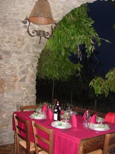 a table with a red table cloth and bottles of wine at Agriturismo Saudon in Mulazzo